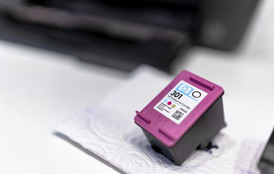 A close-up of a printer ink cartridge resting on a paper towel, showcasing its design and details.